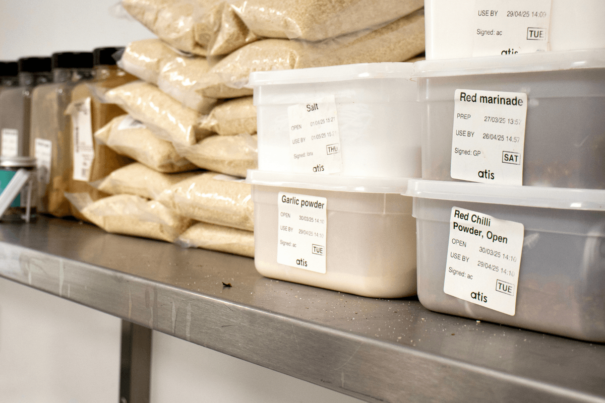 Kitchen shelf with plastic containers all labelled with Dill stock rotation labels